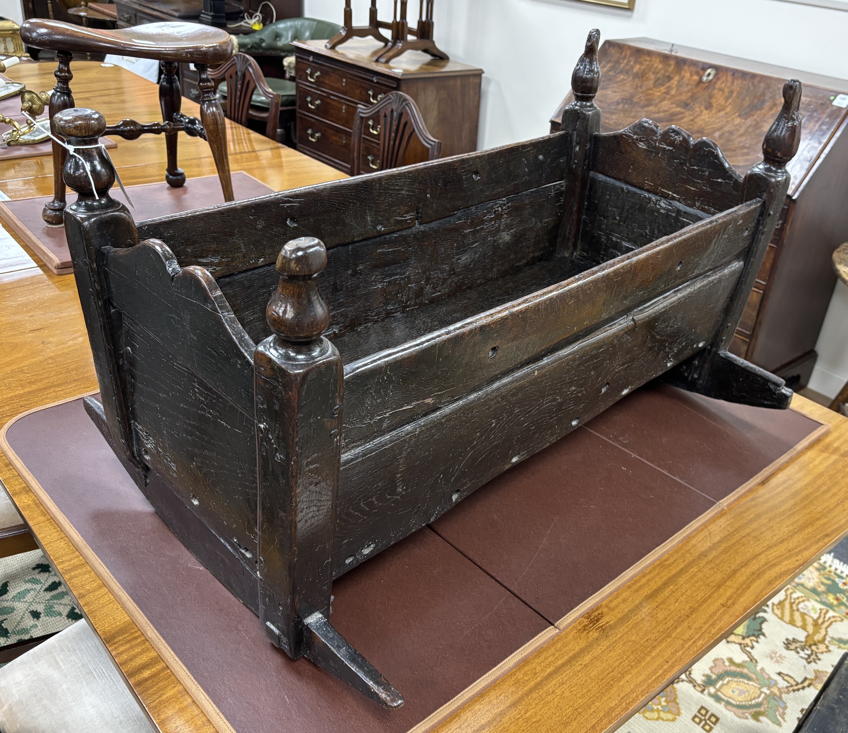 A 17th century oak rocking crib, width 90cm, depth 64cm, height 49cm